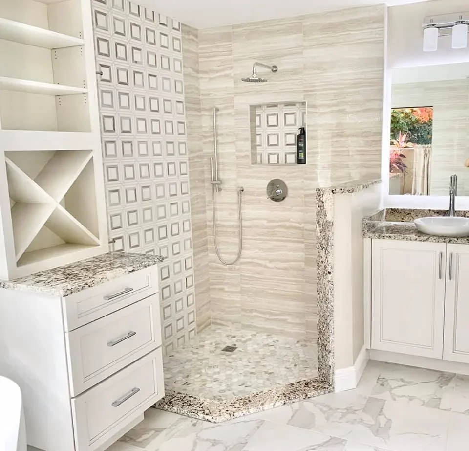 Master bathroom with linear tile shower, white cabinetry, granite counters, and pebble shower floor