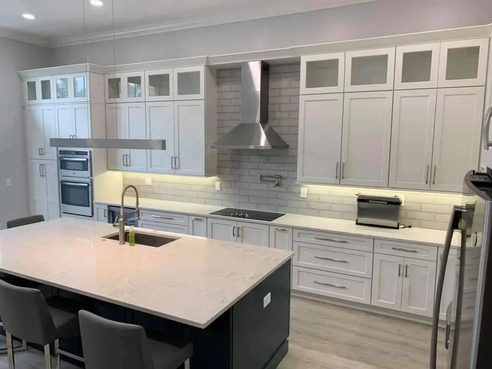 White kitchen cabinets, quartz countertops, gray subway tile backsplash, stainless steel appliances